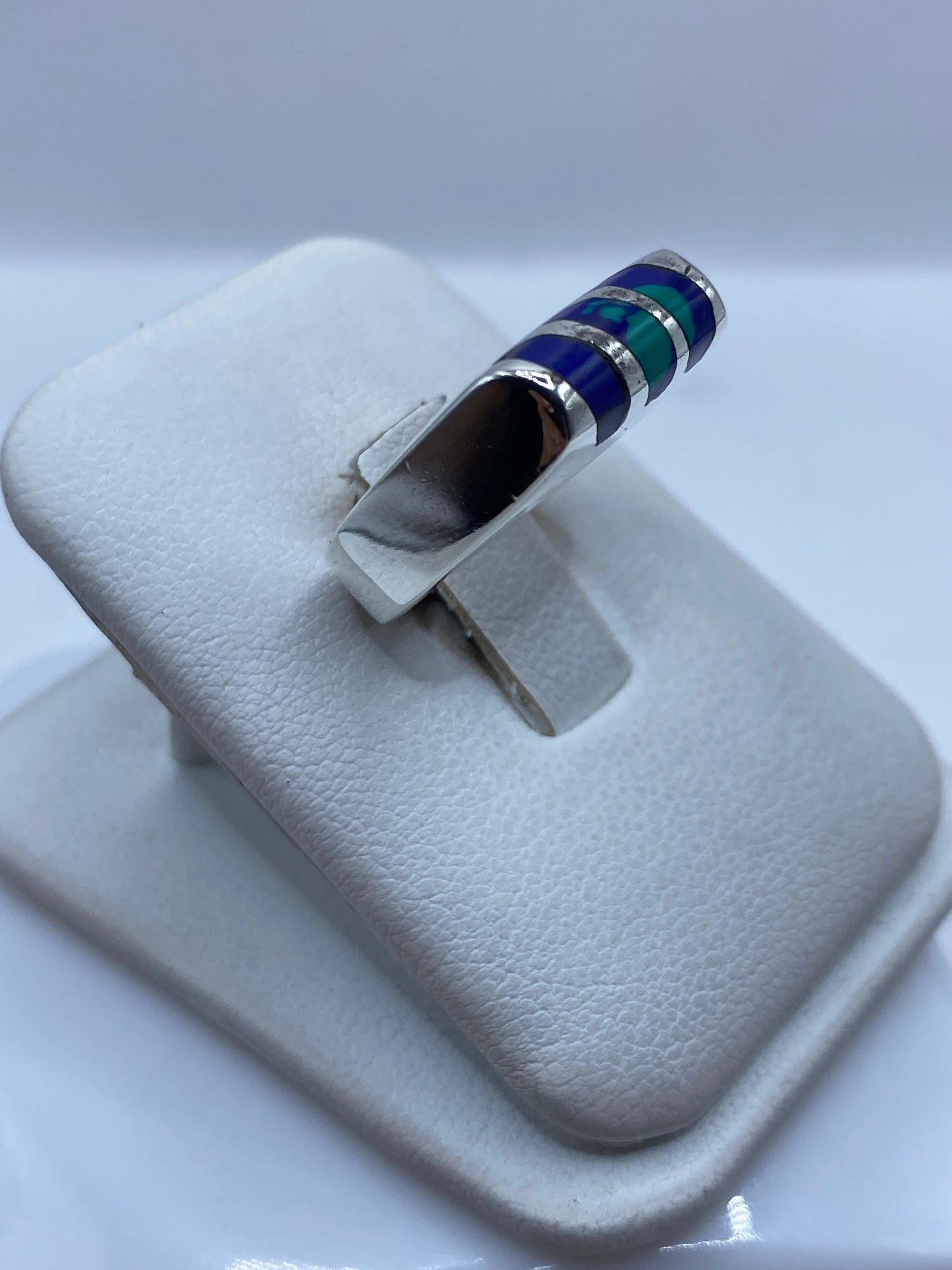Detalle lateral del anillo mostrando la alternancia de plata y piedra azul