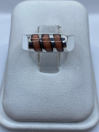 Anillo de plata .925 con coral rojo engastado a mano, sobre presentador blanco