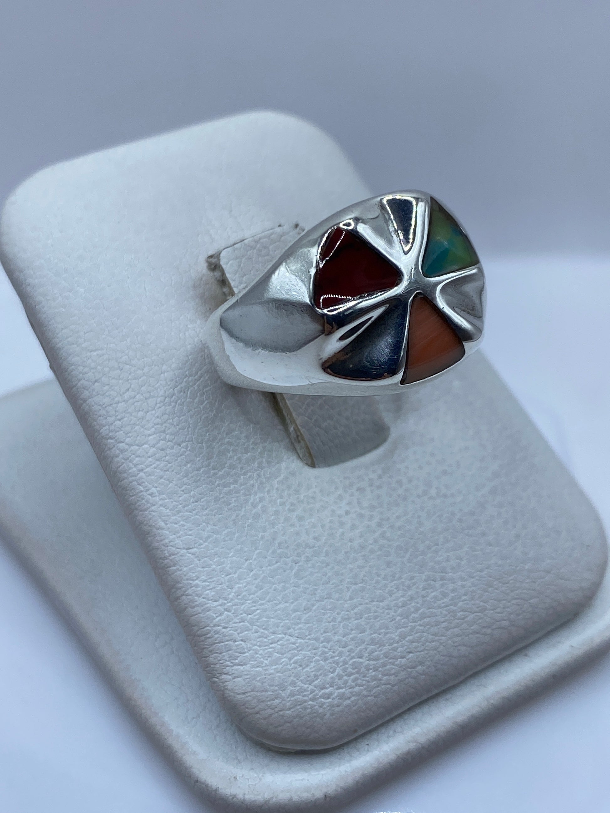 Detalle frontal del anillo mostrando el coral rojo brillante engastado en plata