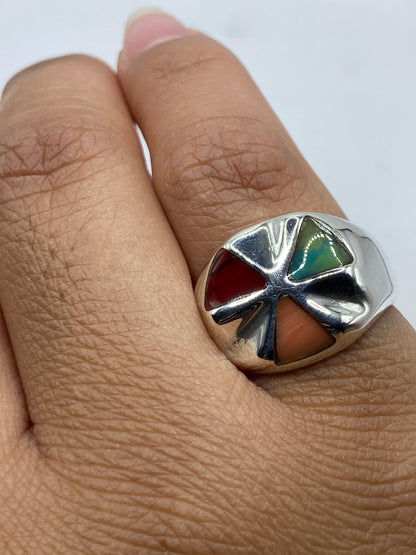 Anillo en la mano mostrando el brillo del coral rojo y el pulido de la plata