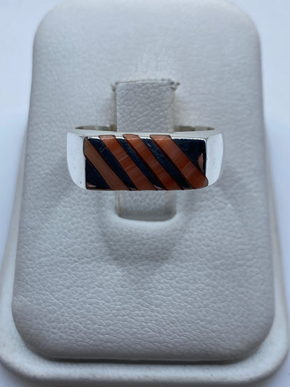 Anillo de plata .925 con coral naranja rojizo engastado en diseño geométrico, vista frontal en estuche blanco