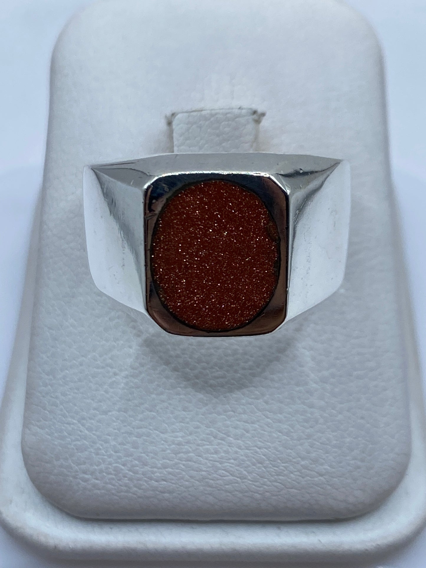 Anillo solitario de plata .925 con piedra café en estuche blanco, vista frontal