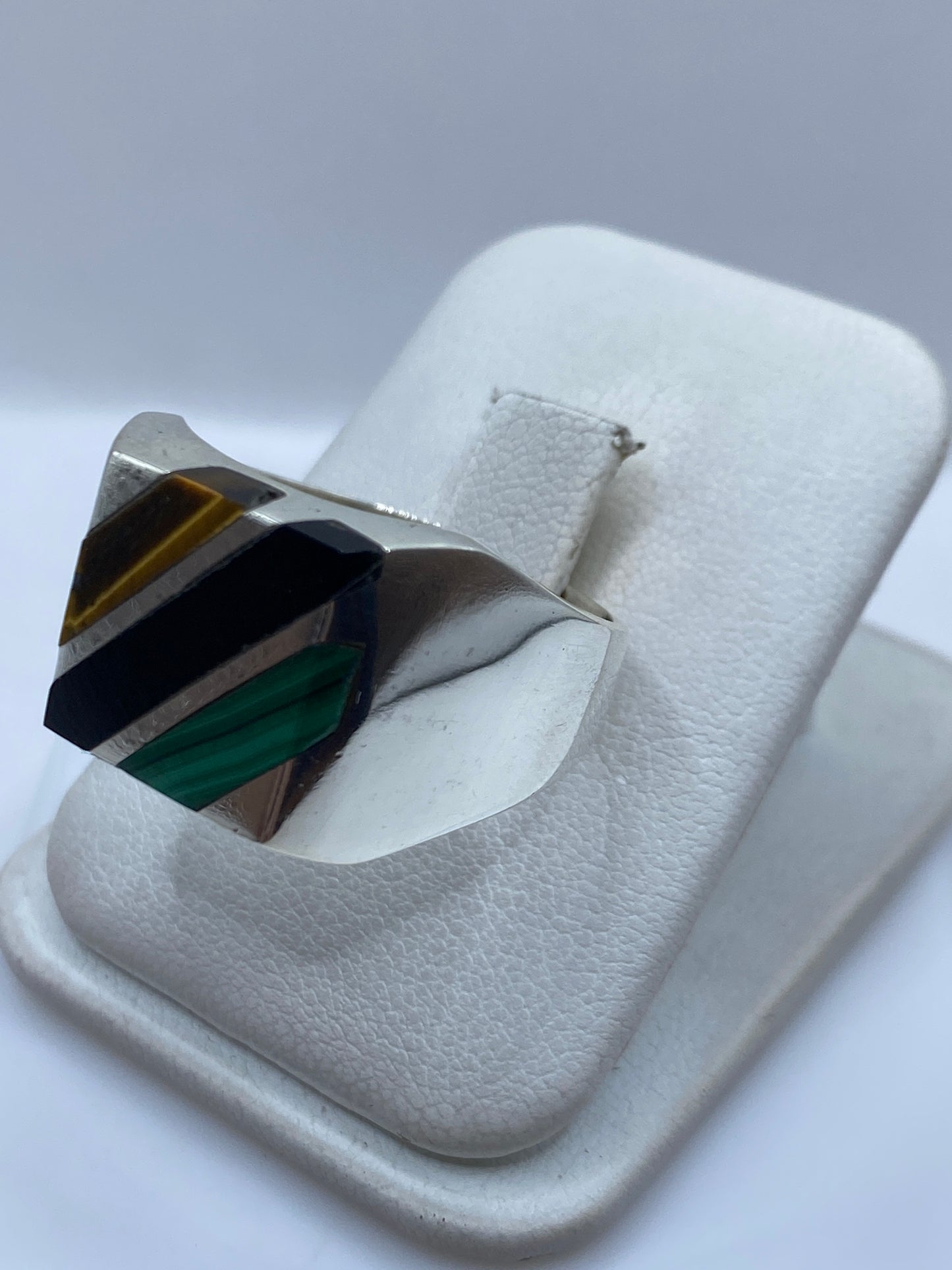 Anillo de plata con malaquita en la mano de un hombre, mostrando el engaste