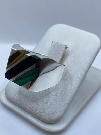Anillo de plata con malaquita en la mano de un hombre, mostrando el engaste