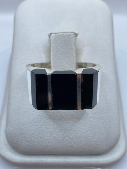 Anillo de plata con tres bloques de ónix negro, visto desde arriba en estuche blanco