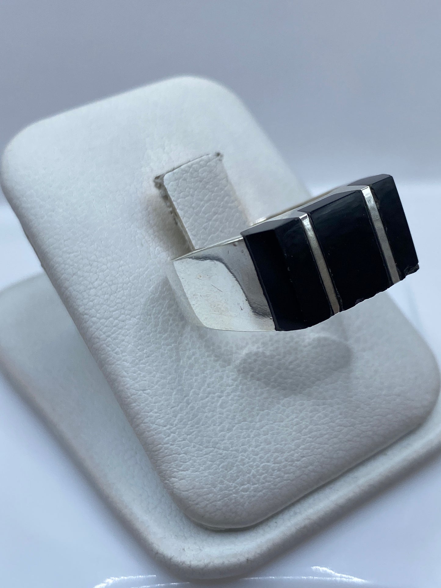 Detalle lateral del anillo de ónix negro mostrando el engaste a mano en plata .925
