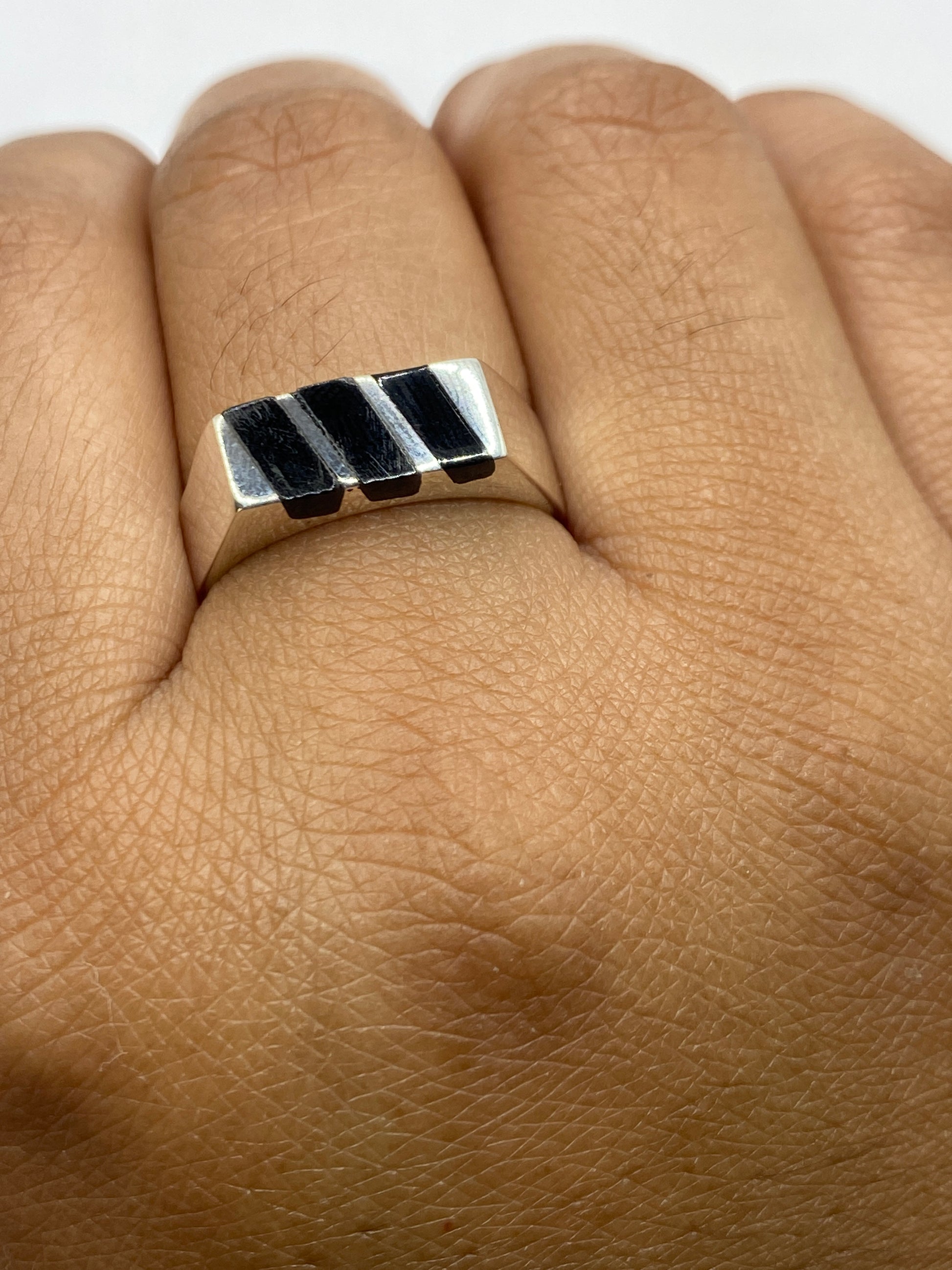 Anillo sobre fondo blanco con marca de Quinto .925 y sellos de Taxco