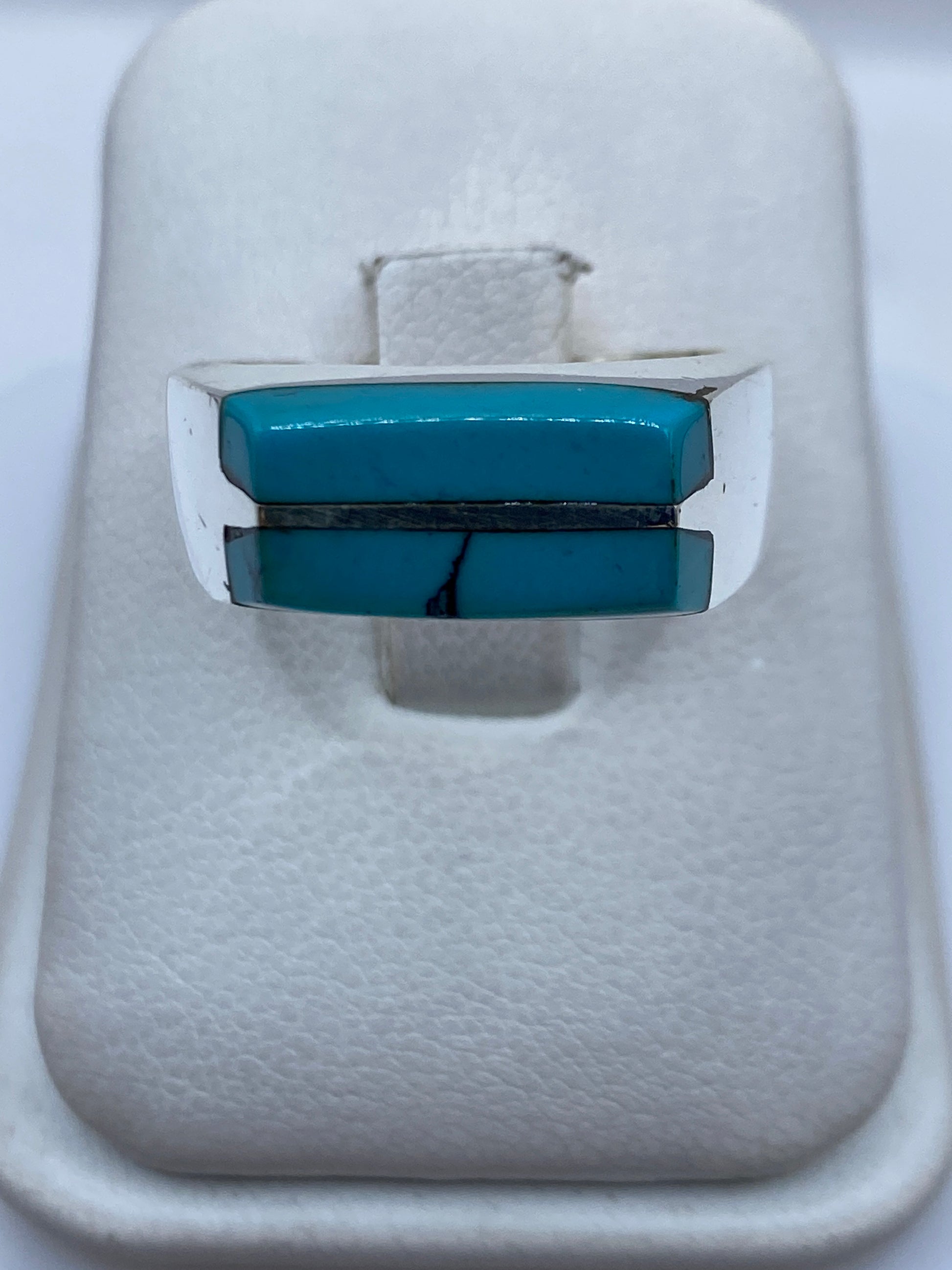 Anillo de plata con turquesa azul cielo engastada en diseño geométrico sobre fondo blanco