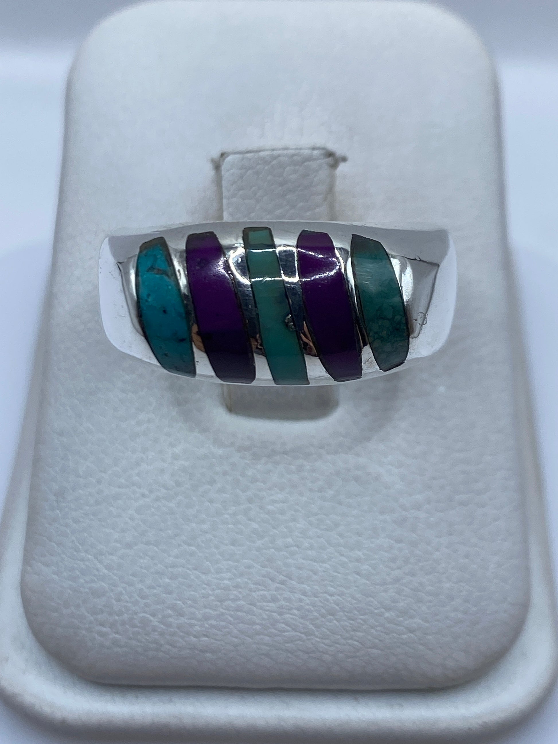 Anillo de plata .925 con cinco incrustaciones de turquesa azul cielo separadas por franjas de plata en la mano
