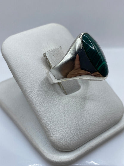 Anillo en mano mostrando el verde profundo de la malaquita y el brillo de la plata