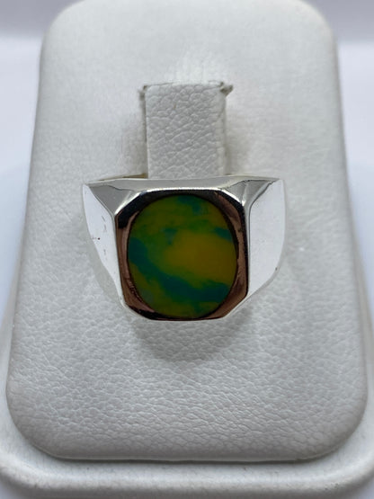 Anillo de plata .925 con piedra amarilla engastada en la mano de una mujer