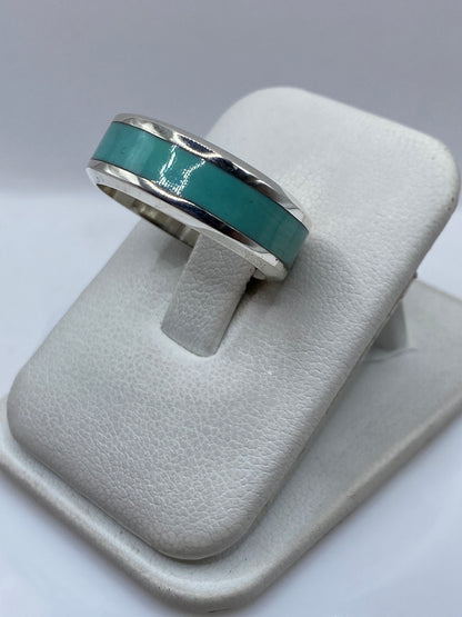 Detalle lateral del anillo mostrando el engaste de turquesa y la banda de plata pulida