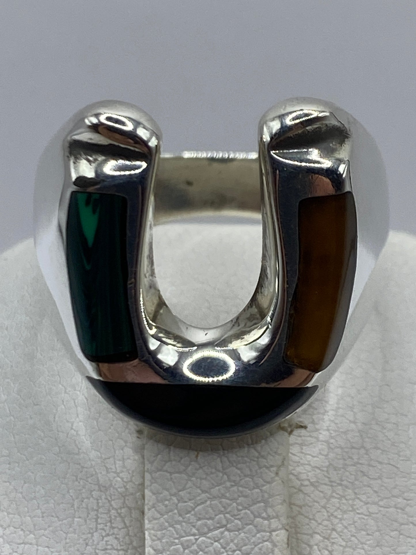 Anillo con malaquita verde en mano de hombre, mostrando proporción y acabado