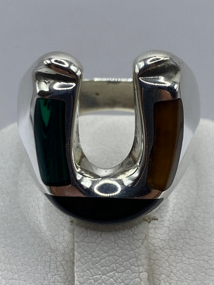 Anillo con malaquita verde en mano de hombre, mostrando proporción y acabado