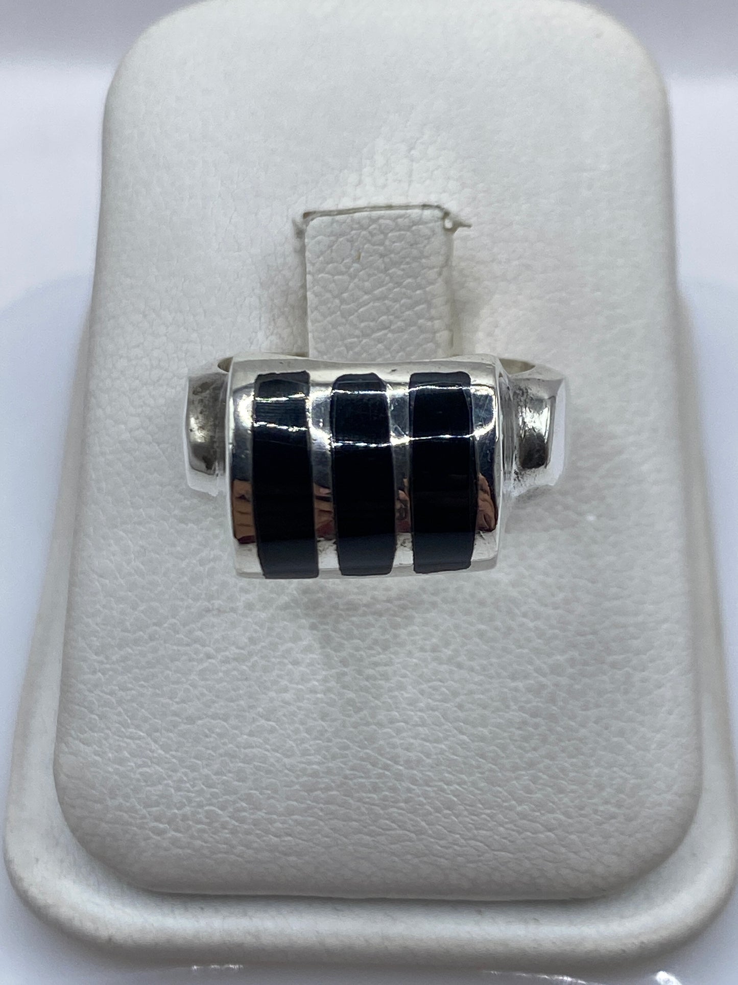 Anillo de plata .925 con tres franjas de ónix negro en la mano de una mujer
