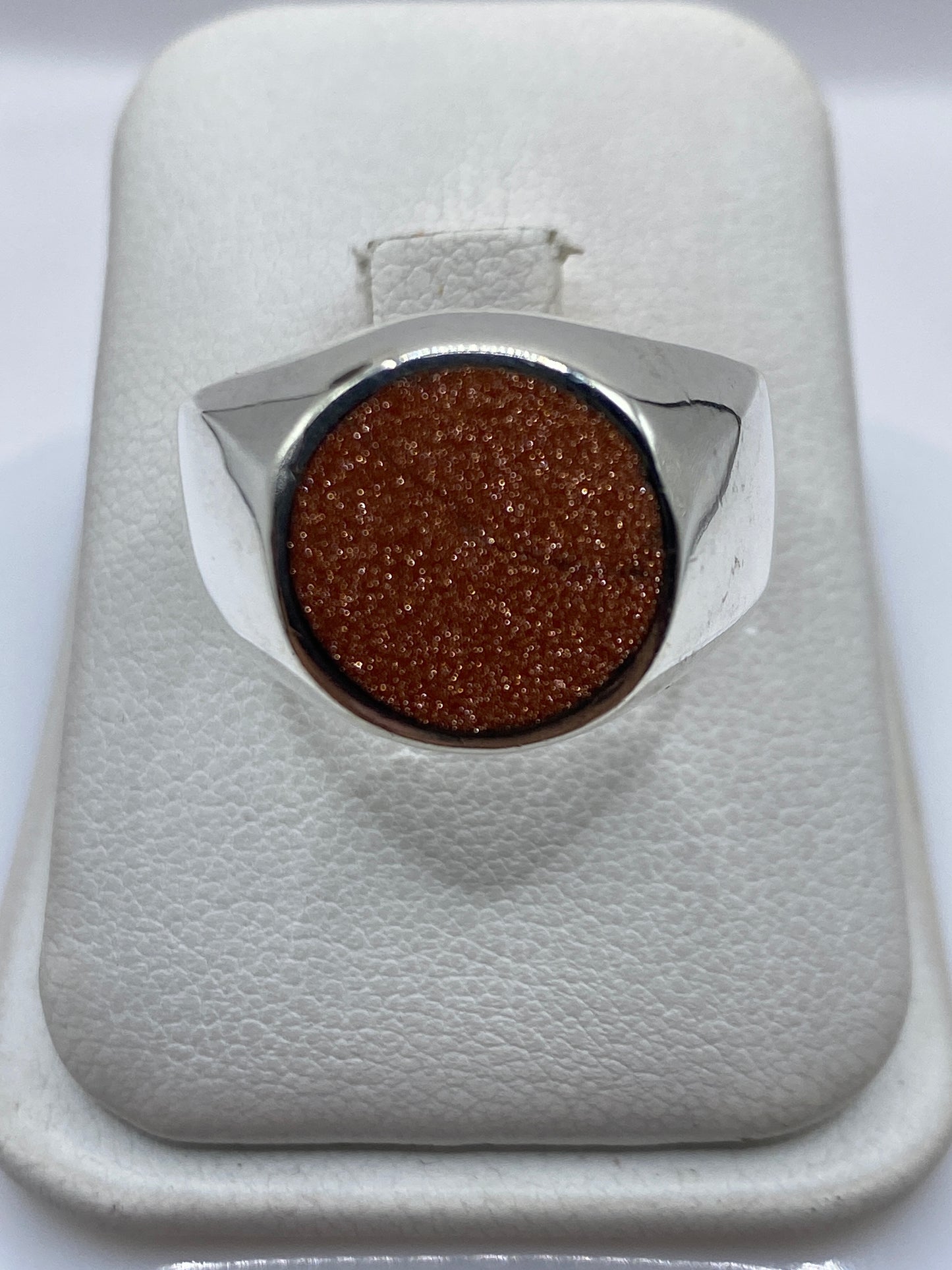 Anillo de plata .925 con piedra engastada en bisel, vista superior en estuche blanco