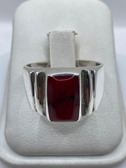Anillo de plata .925 con coral rojo natural engastado, visto de frente en estuche blanco