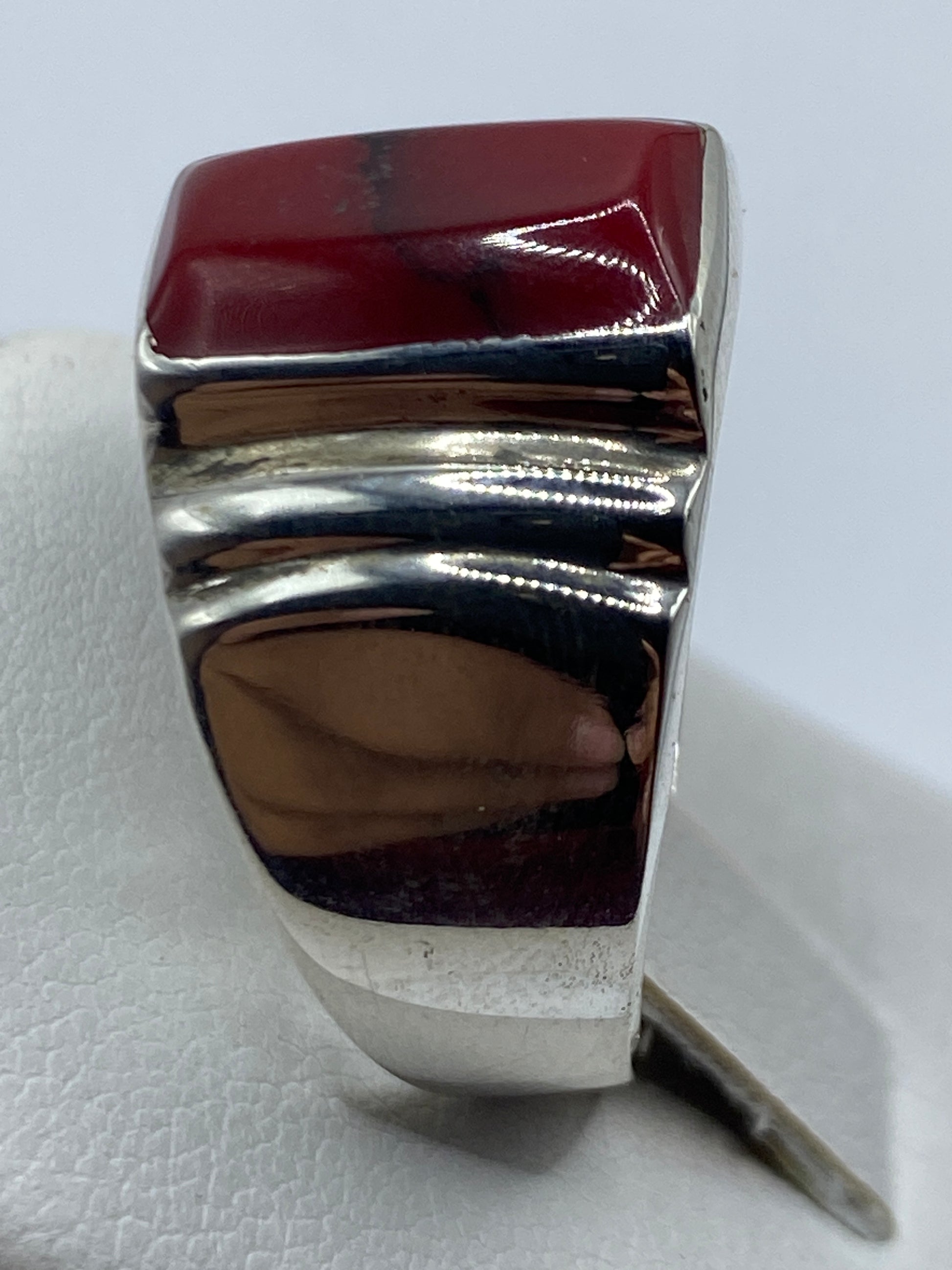 Anillo en dedo mostrando presencia escultural del coral rojo en plata .925