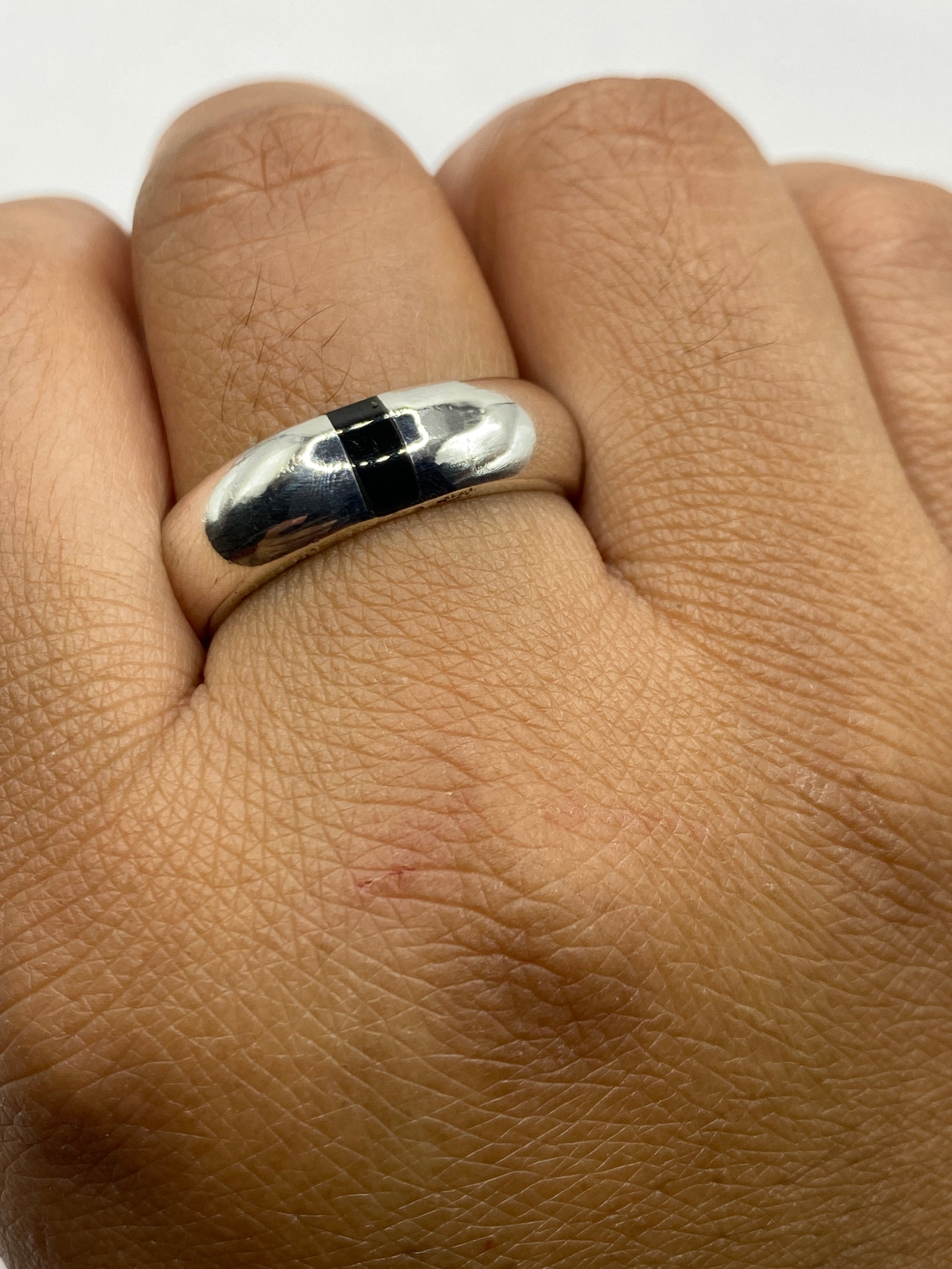 Anillo sobre fondo blanco exhibiendo el brillo de la plata .925 y el Quinto