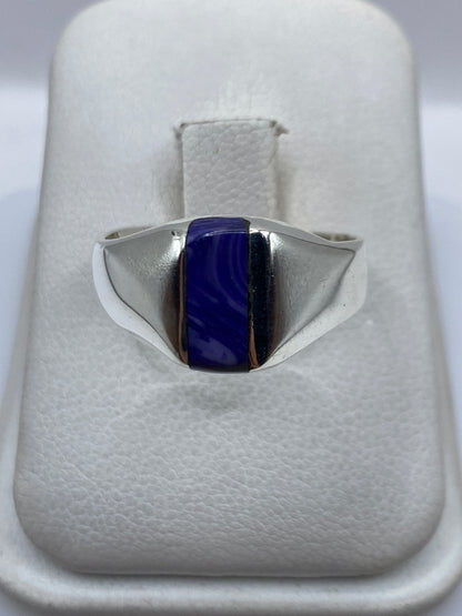 Anillo de plata .925 con piedra morada engastada, visto de frente sobre la mano