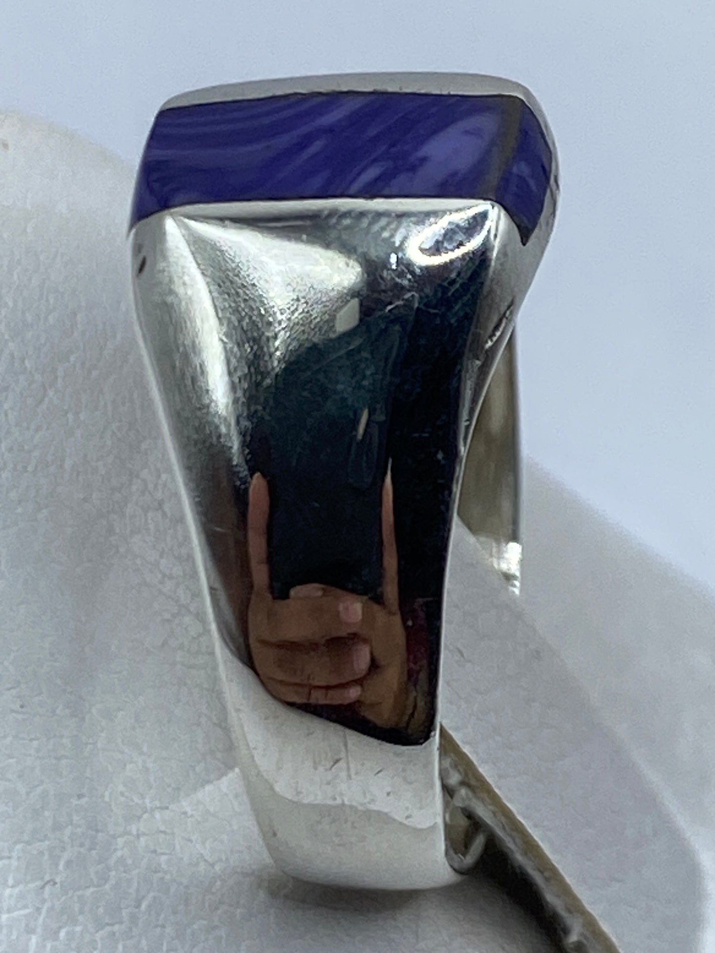 Detalle de la piedra morada pulida con brillo espejo en el anillo de plata