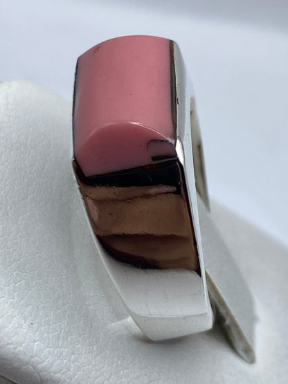 Anillo de plata con piedra rosa puesto en dedo, brillo natural de la plata