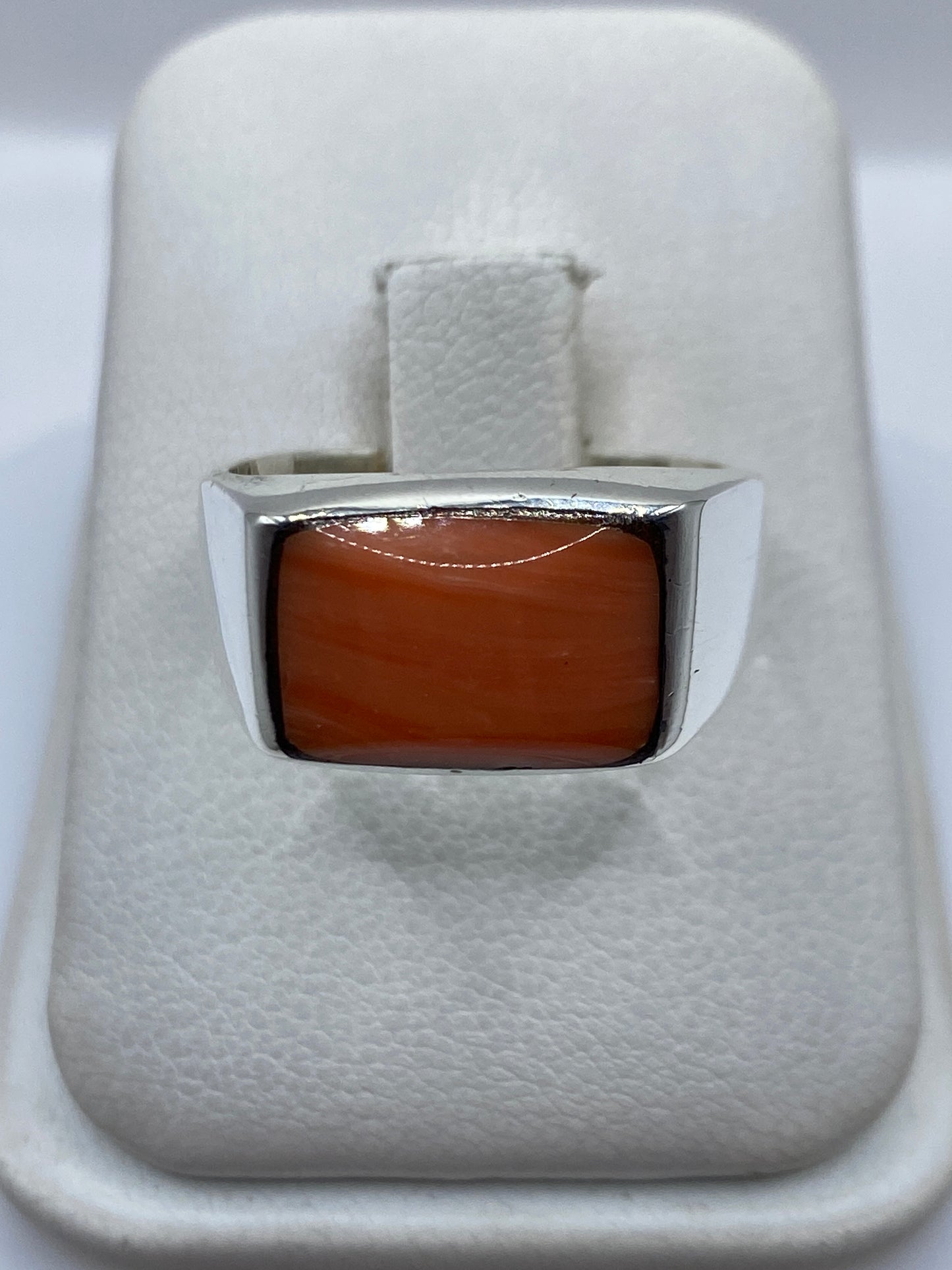 Anillo de plata .925 con coral engastado, vista frontal sobre estuche blanco