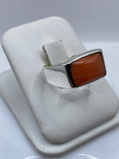Detalle lateral del anillo de plata y coral, mostrando el engaste a mano