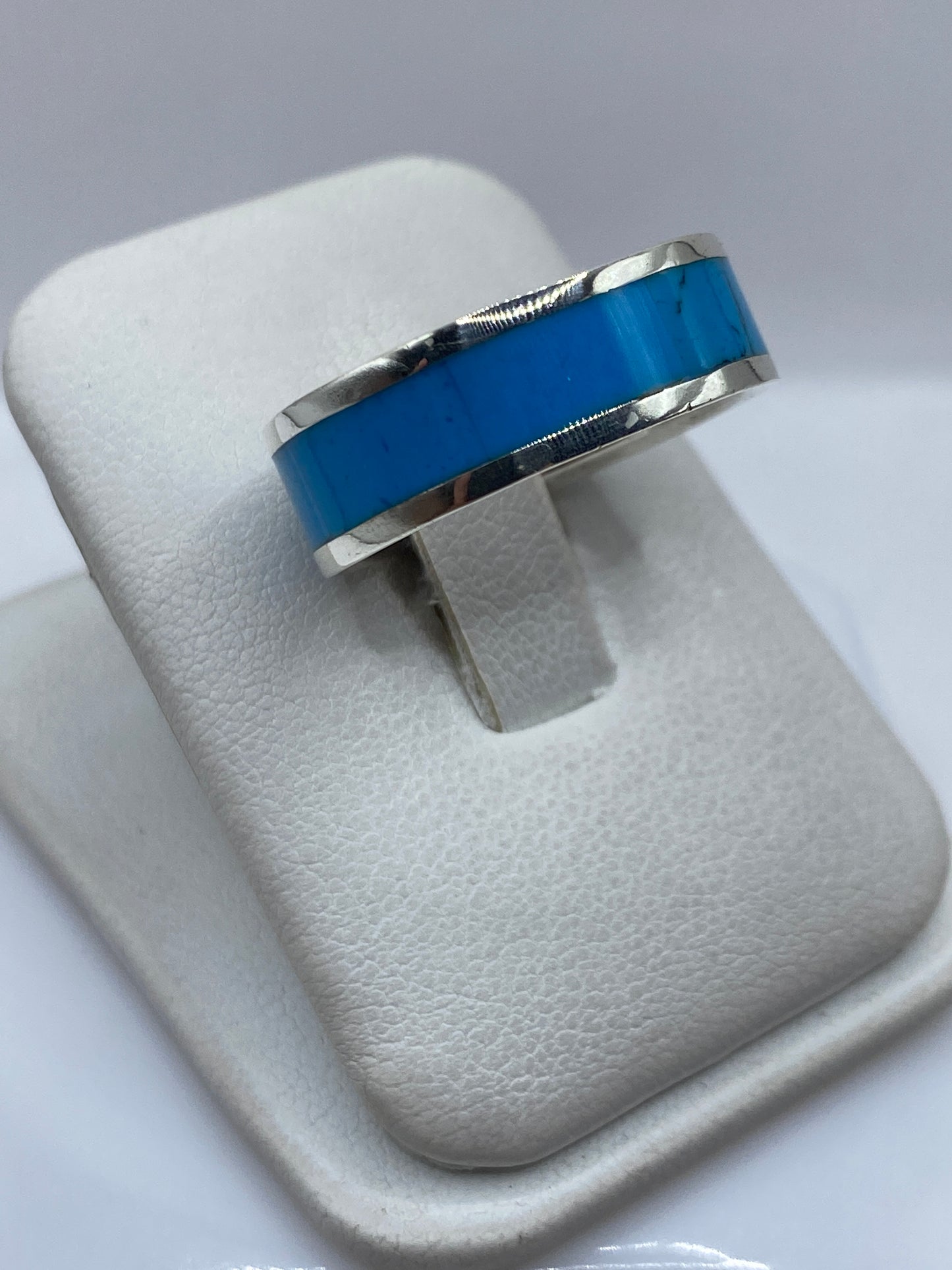 Detalle lateral del anillo mostrando el engaste de turquesa y el pulido de la plata .950