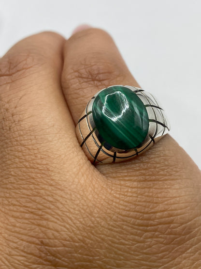Anillo en la mano mostrando el peso y la proporción del diseño con la malaquita