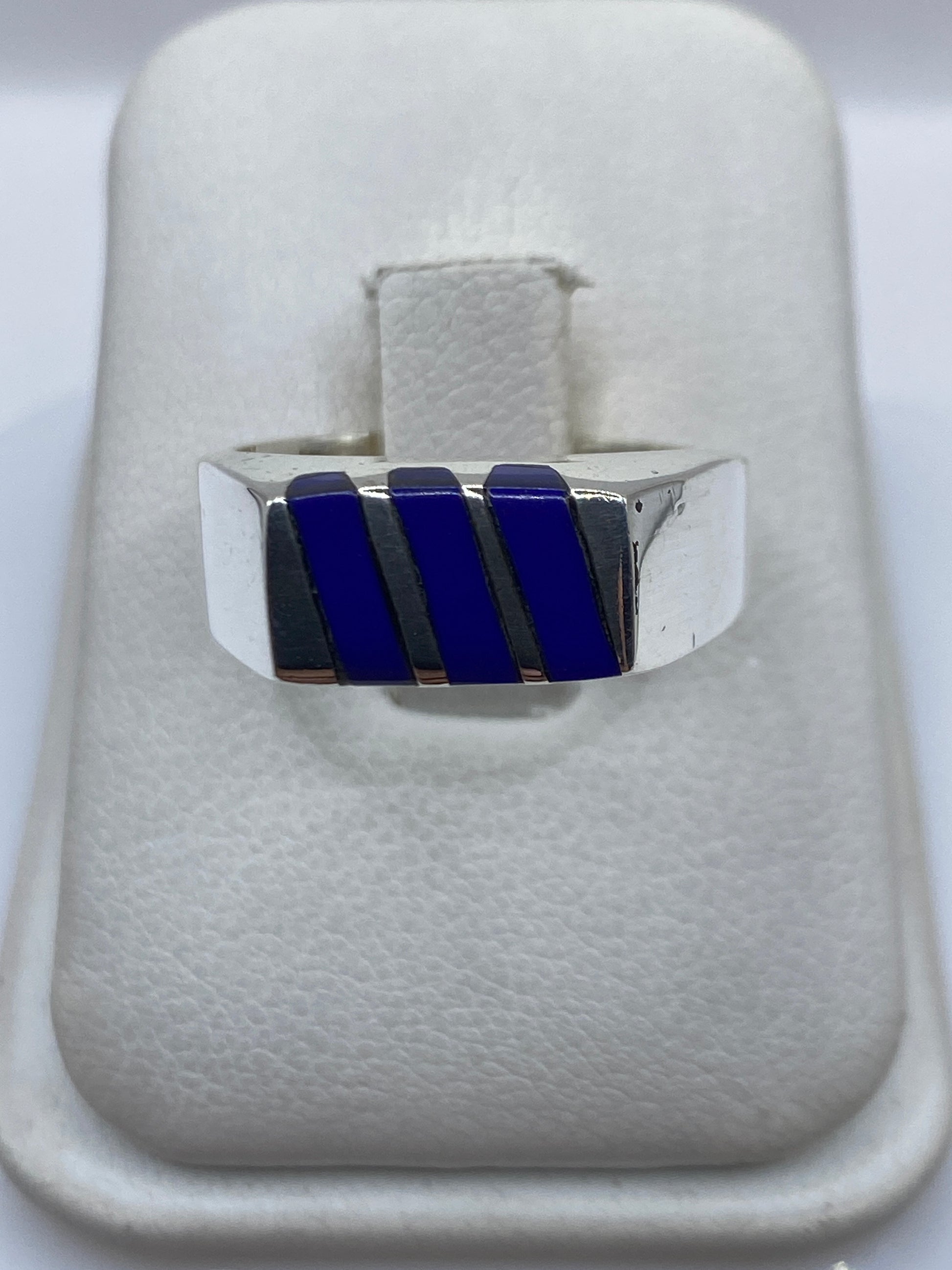 Anillo de plata con tres rectángulos de piedra azul engastada, vista frontal sobre fondo blanco