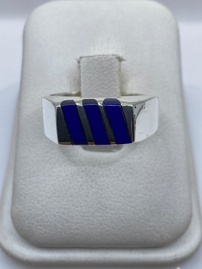 Anillo de plata con tres rectángulos de piedra azul engastada, vista frontal sobre fondo blanco