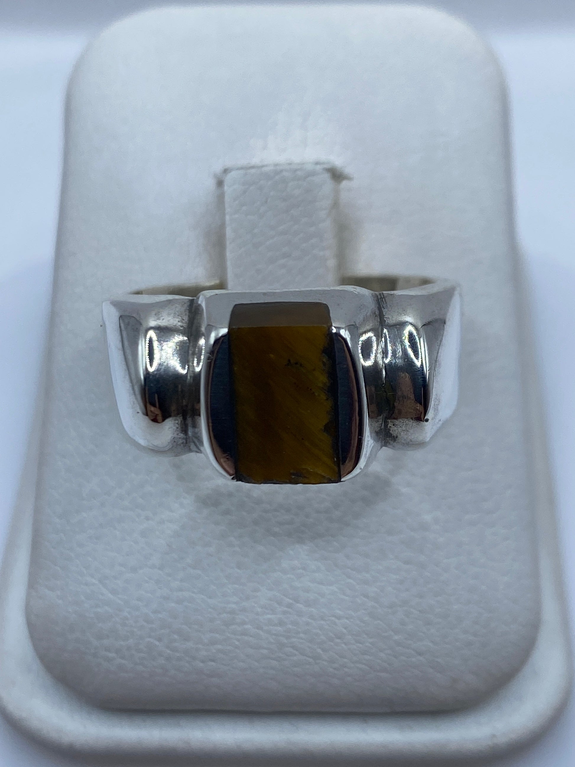 Anillo de plata .925 con piedra engastada en el centro, visto de frente en estuche blanco