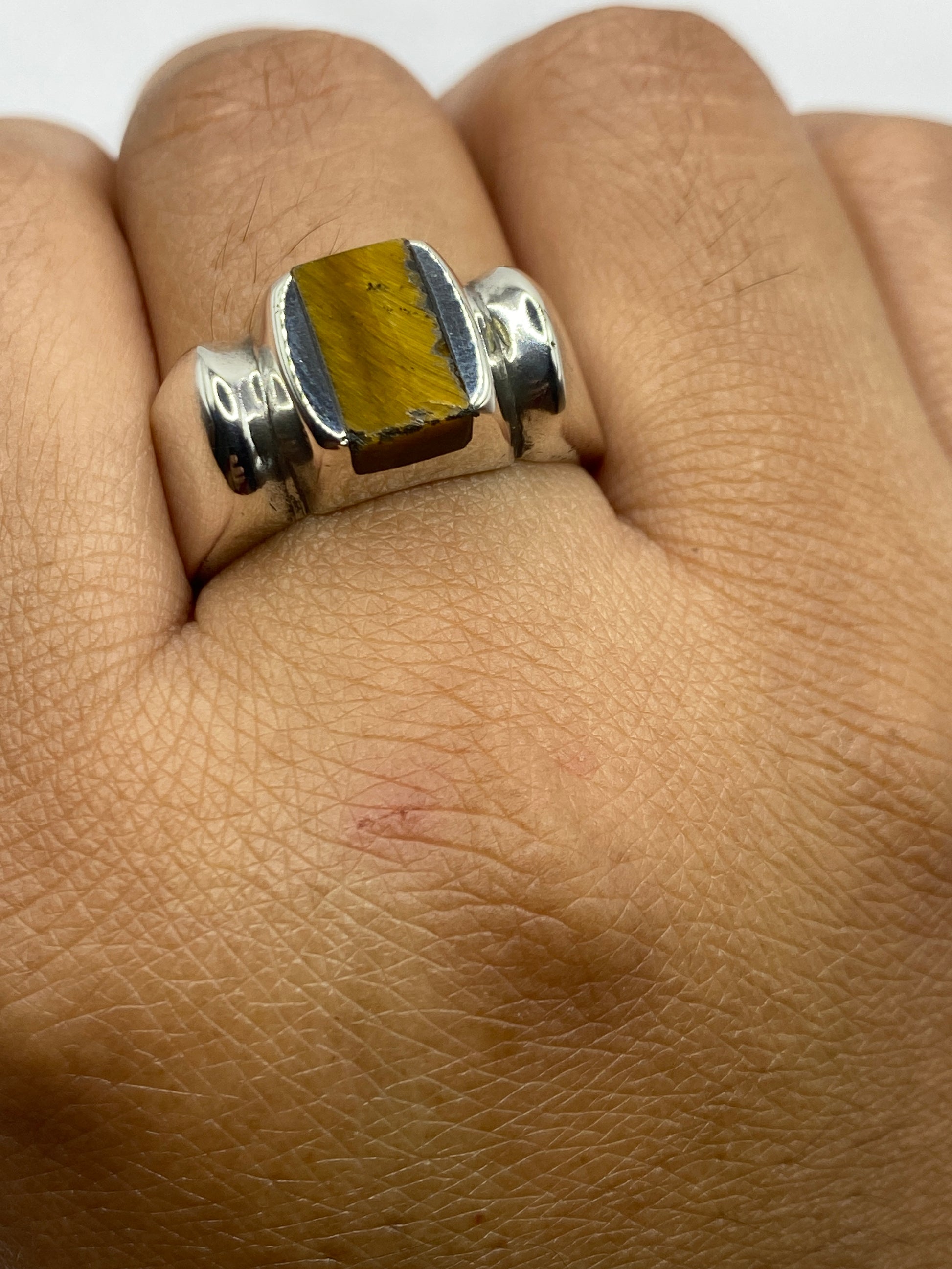 Anillo puesto en dedo mostrando presencia y peso, con la piedra centrada