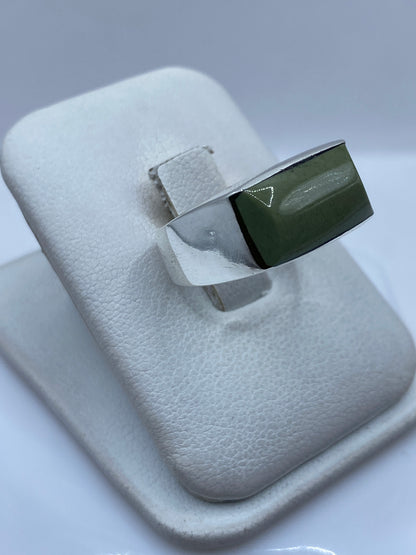 Detalle lateral del anillo mostrando el engaste a mano y la piedra verde