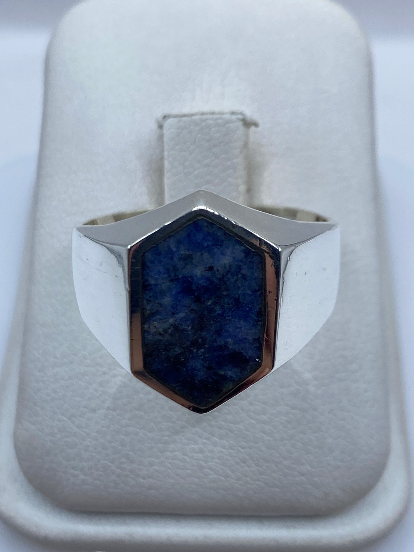 Anillo de plata con lapislázuli azul profundo en la palma de una mano