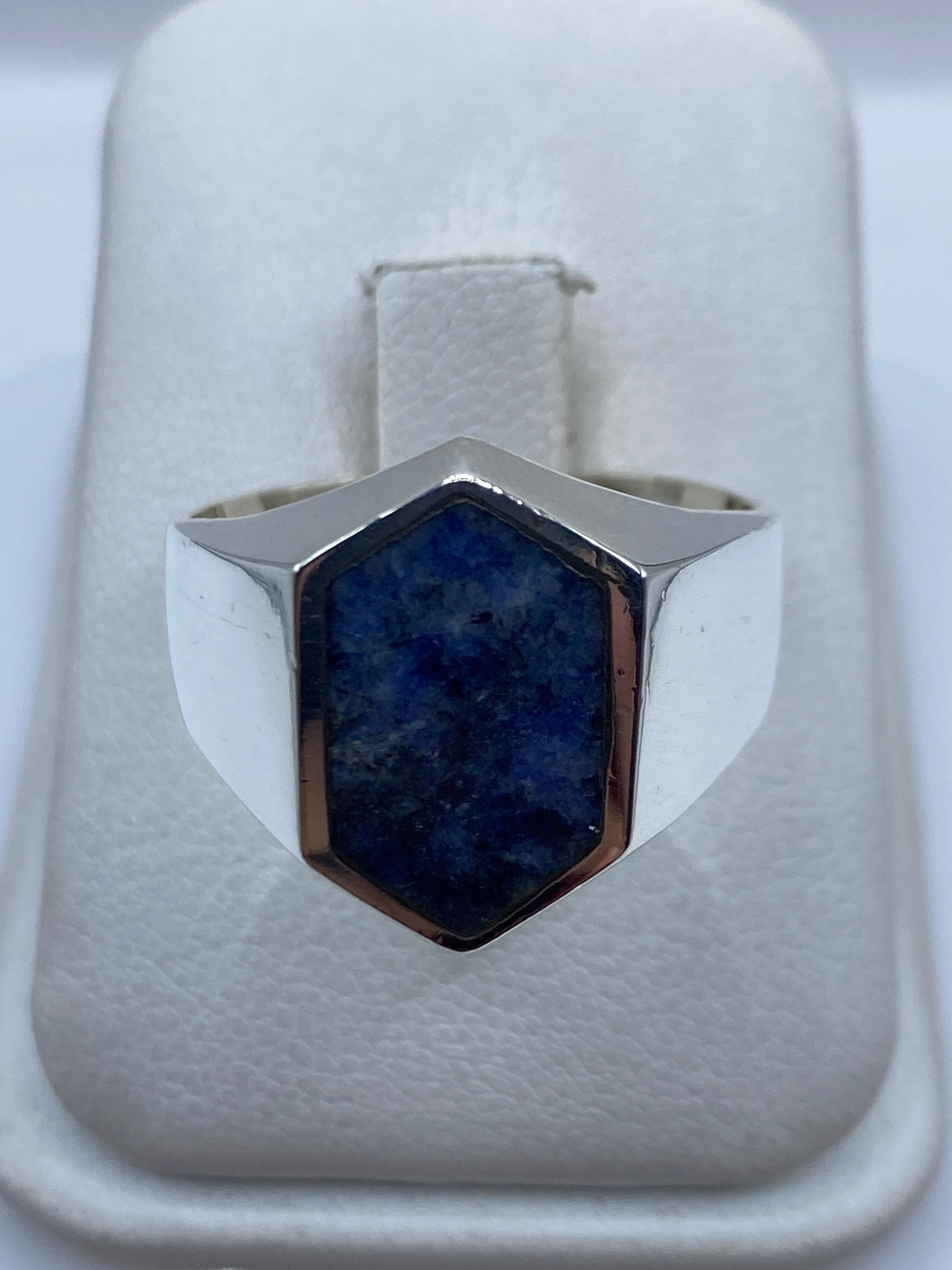 Anillo de plata con lapislázuli azul profundo en la palma de una mano