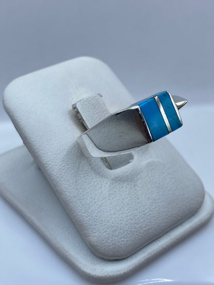 Detalle lateral del anillo mostrando el engaste a mano de la turquesa