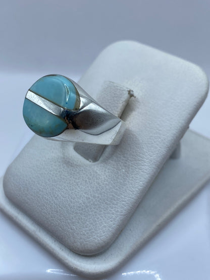 Detalle lateral del anillo mostrando el engaste a mano de la turquesa en plata pulida