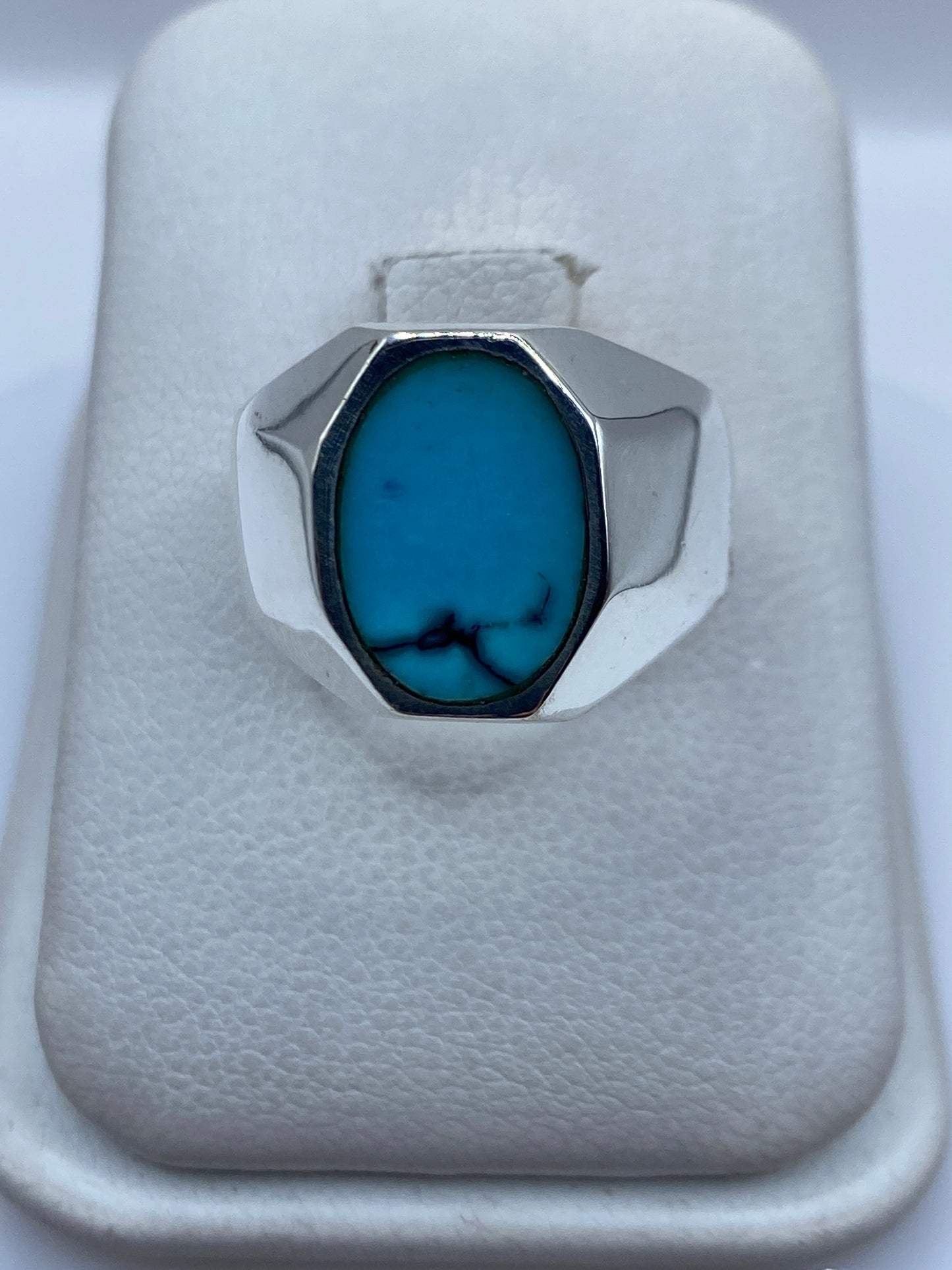 Anillo de plata con turquesa azul cielo engastada, visto desde arriba sobre fondo blanco
