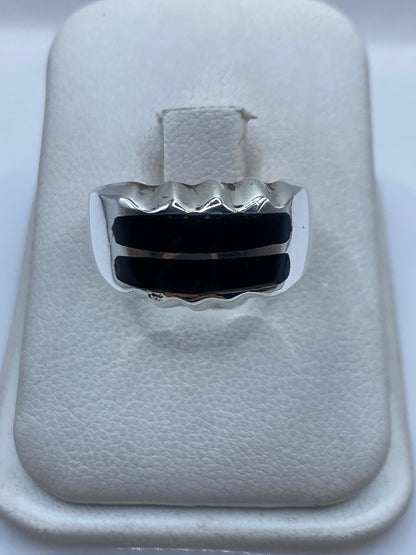 Anillo de plata .925 con dos franjas de ónix negro engastadas, visto de frente en estuche blanco