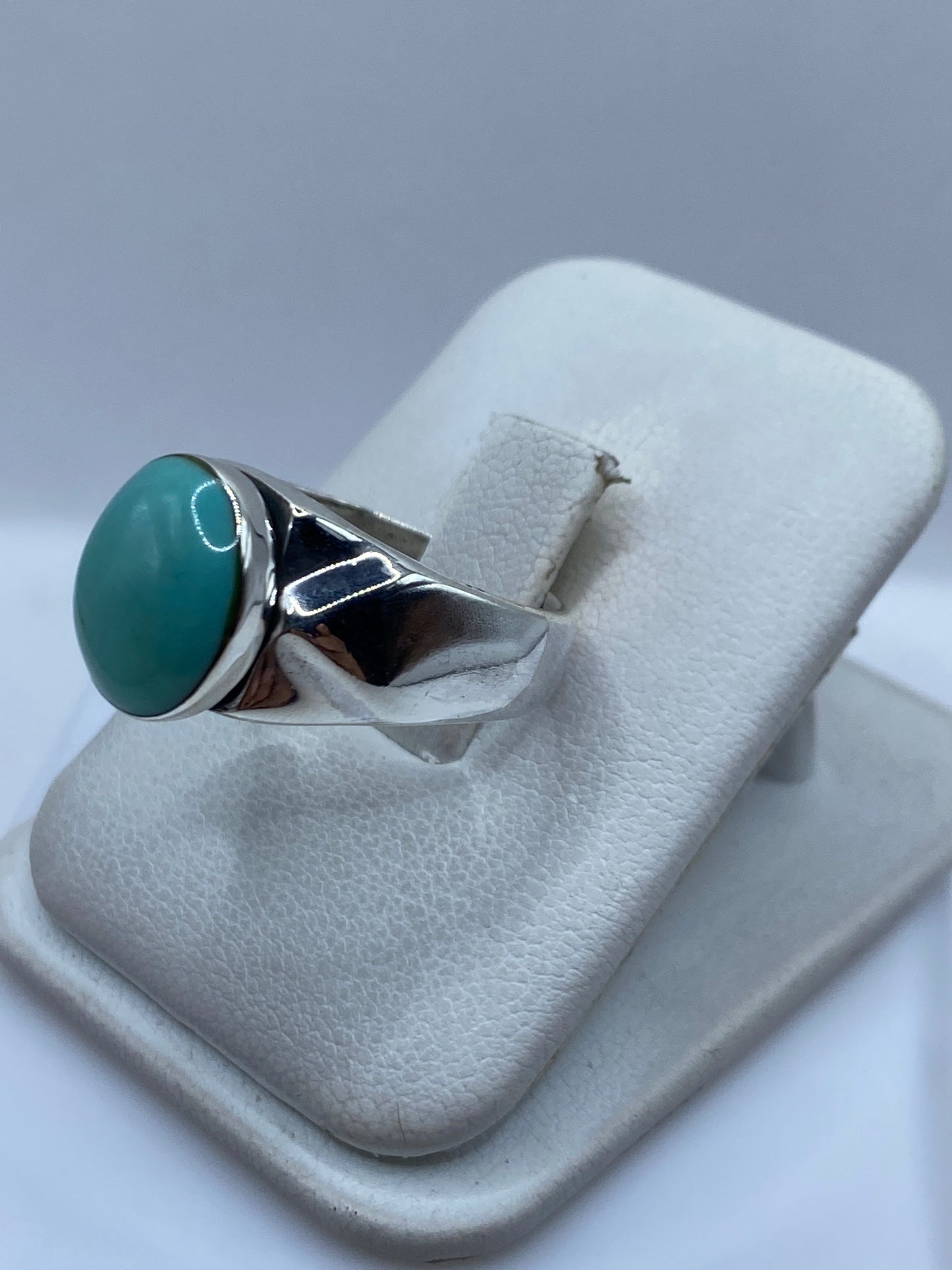 Anillo de turquesa y plata desde un ángulo lateral, mostrando el engaste a mano