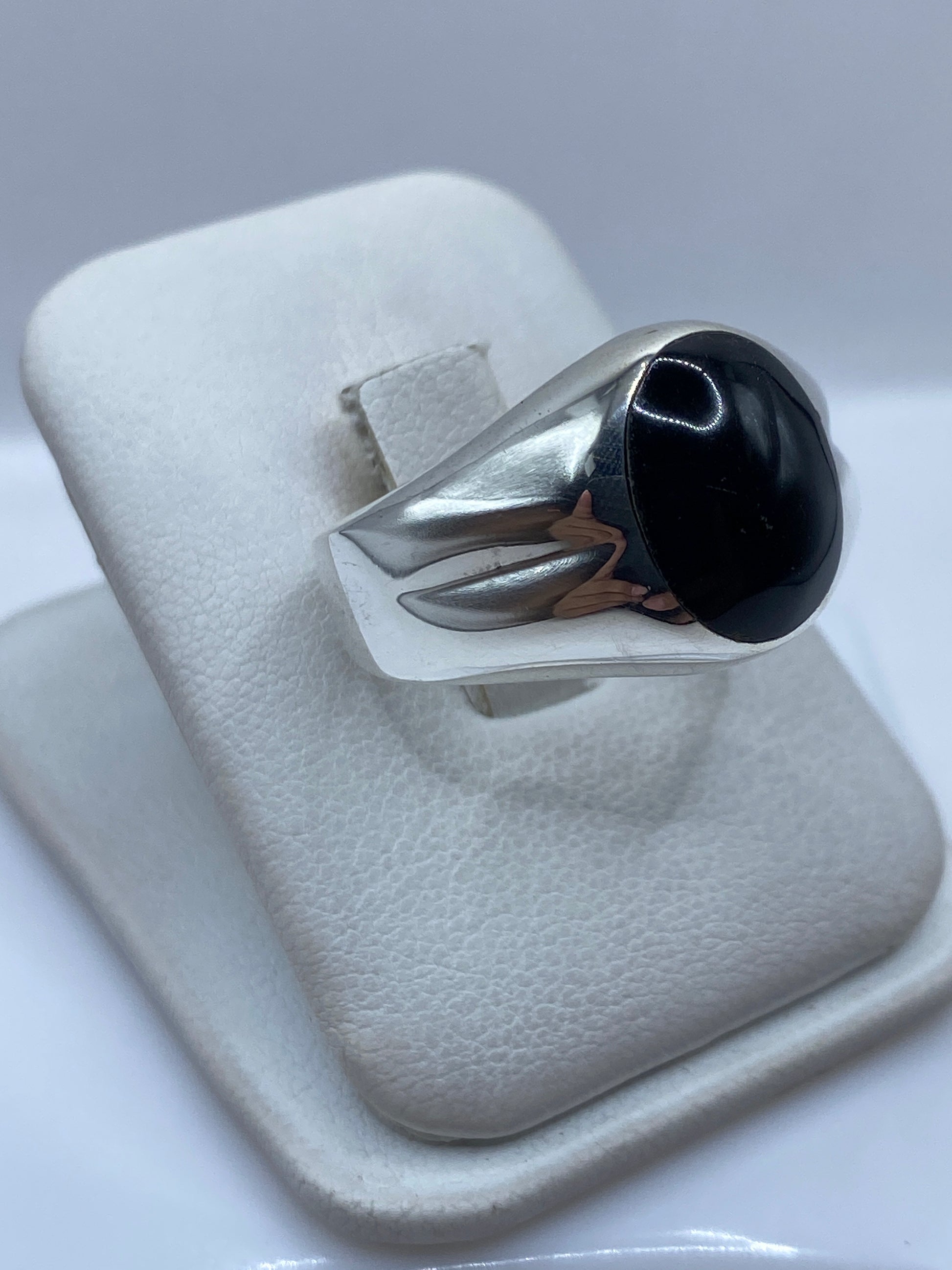 Anillo de plata con piedra onix negra en la mano de un hombre