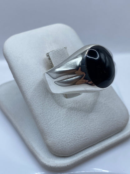 Anillo de plata con piedra onix negra en la mano de un hombre