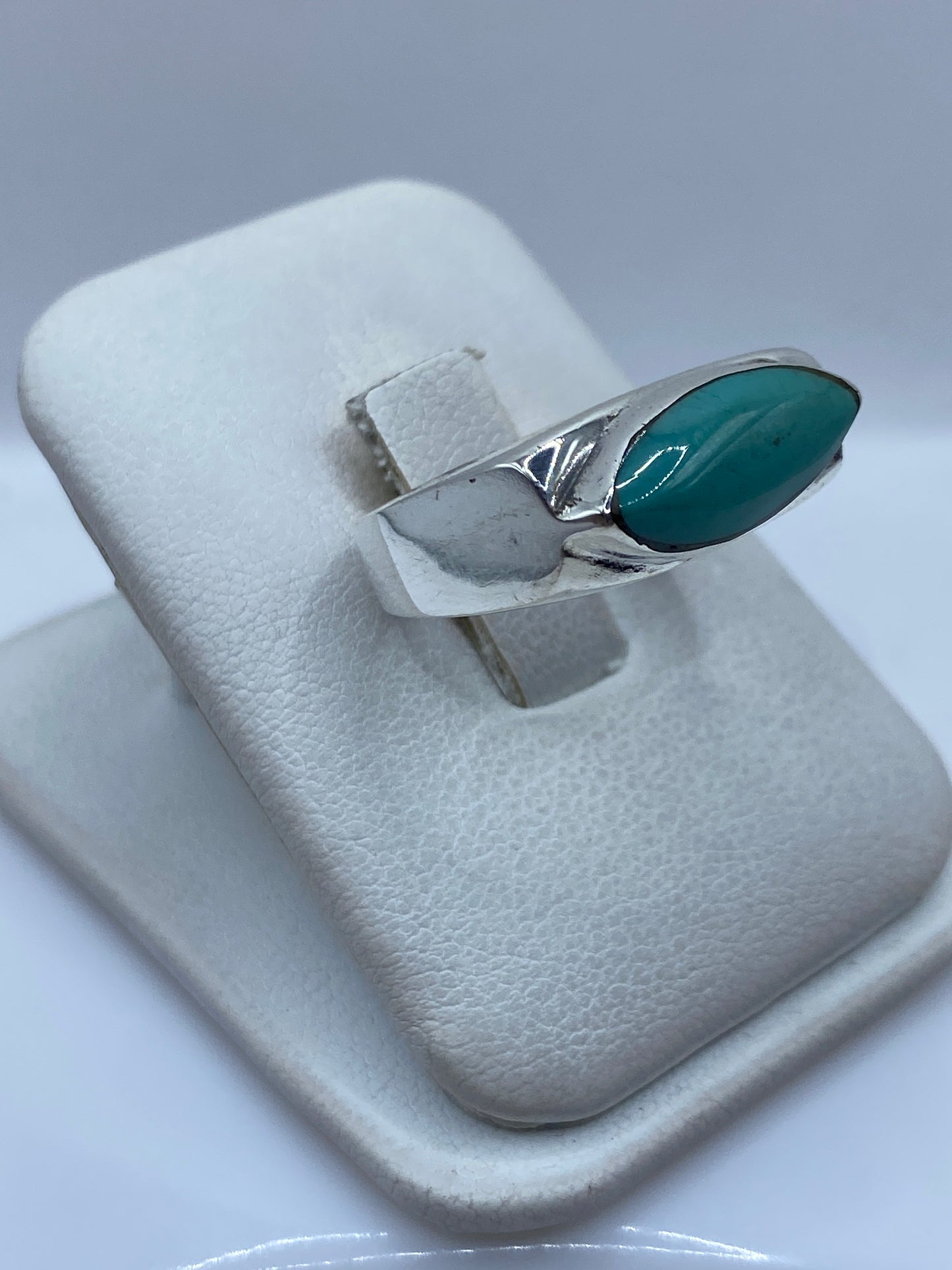 Anillo de turquesa y plata visto desde un lado, mostrando el engaste a mano