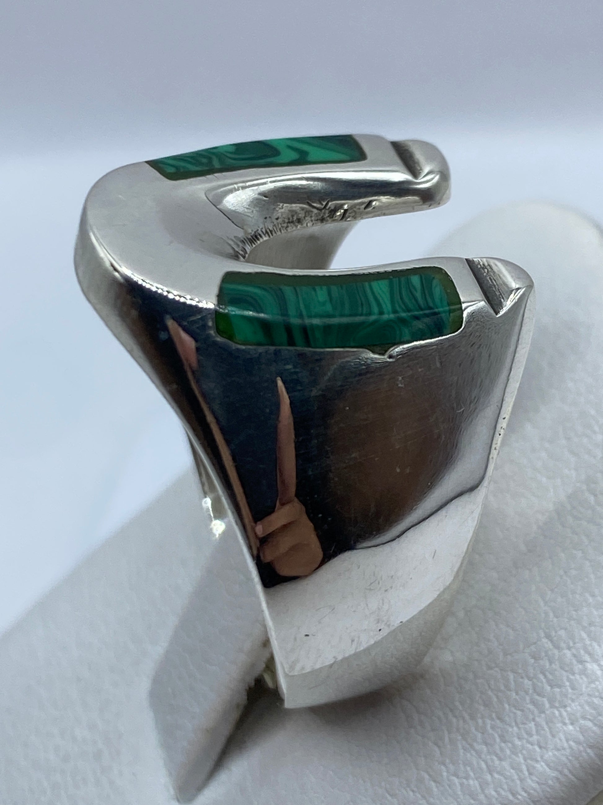 Anillo de plata con piedra verde en la mano de un hombre