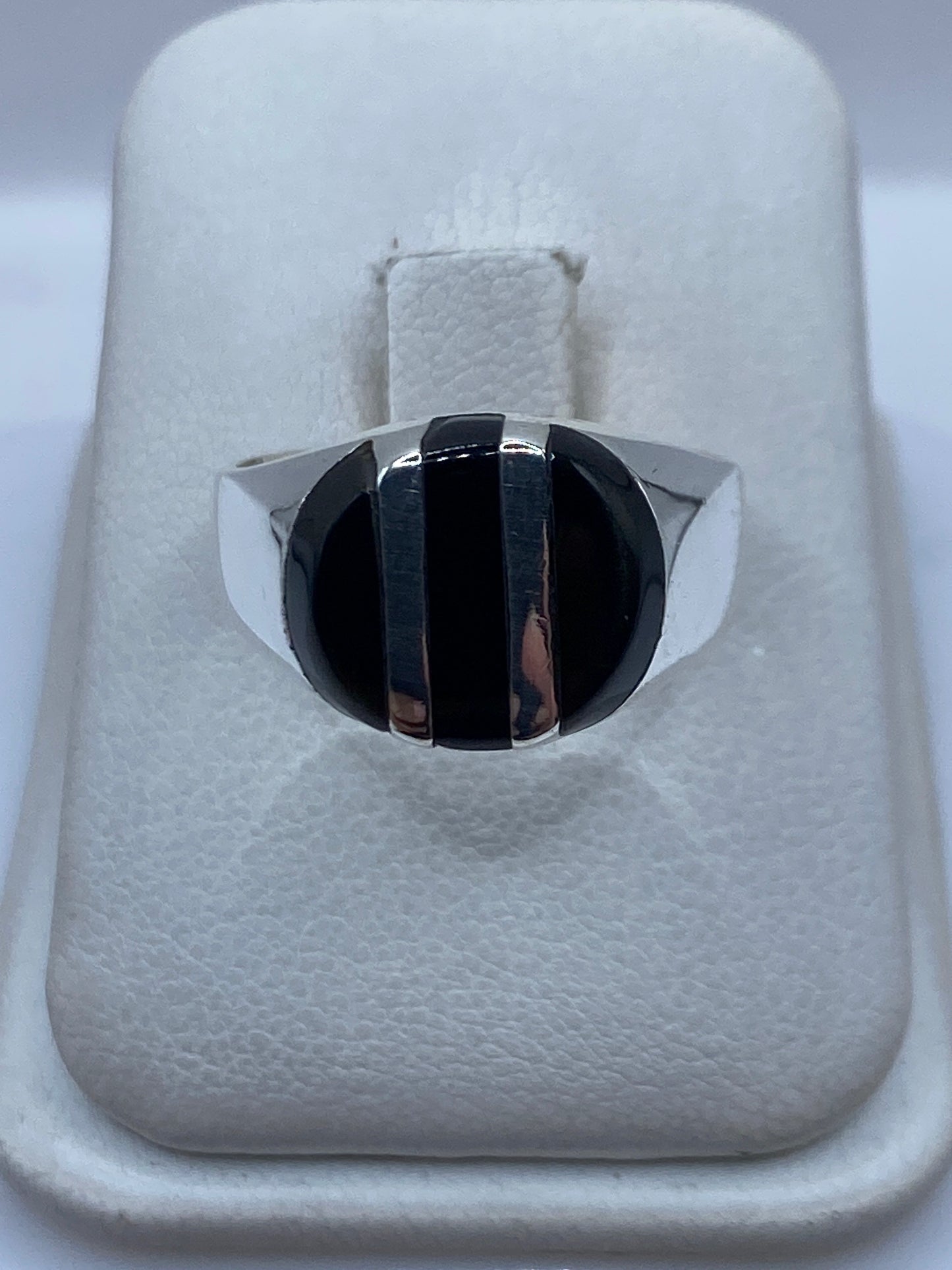 Anillo de plata .925 con ónix negro pulido en mano de hombre
