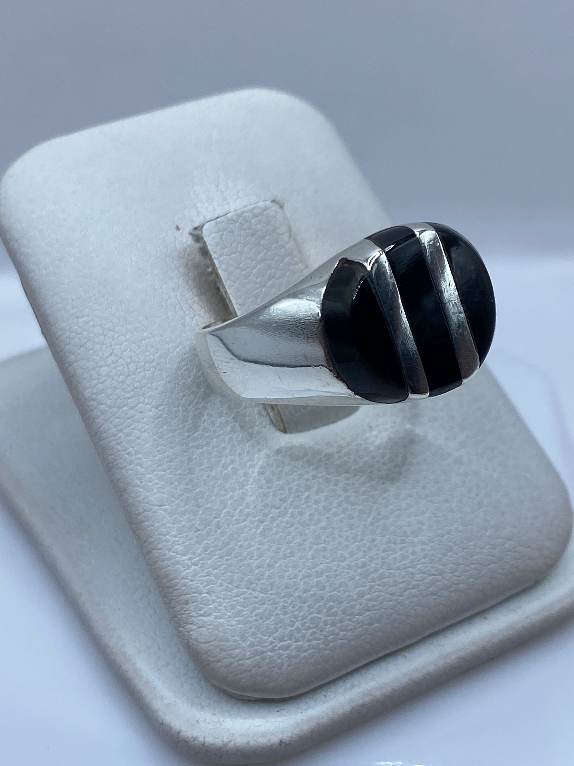 Vista frontal del anillo mostrando el engaste de ónix negro y la banda de plata