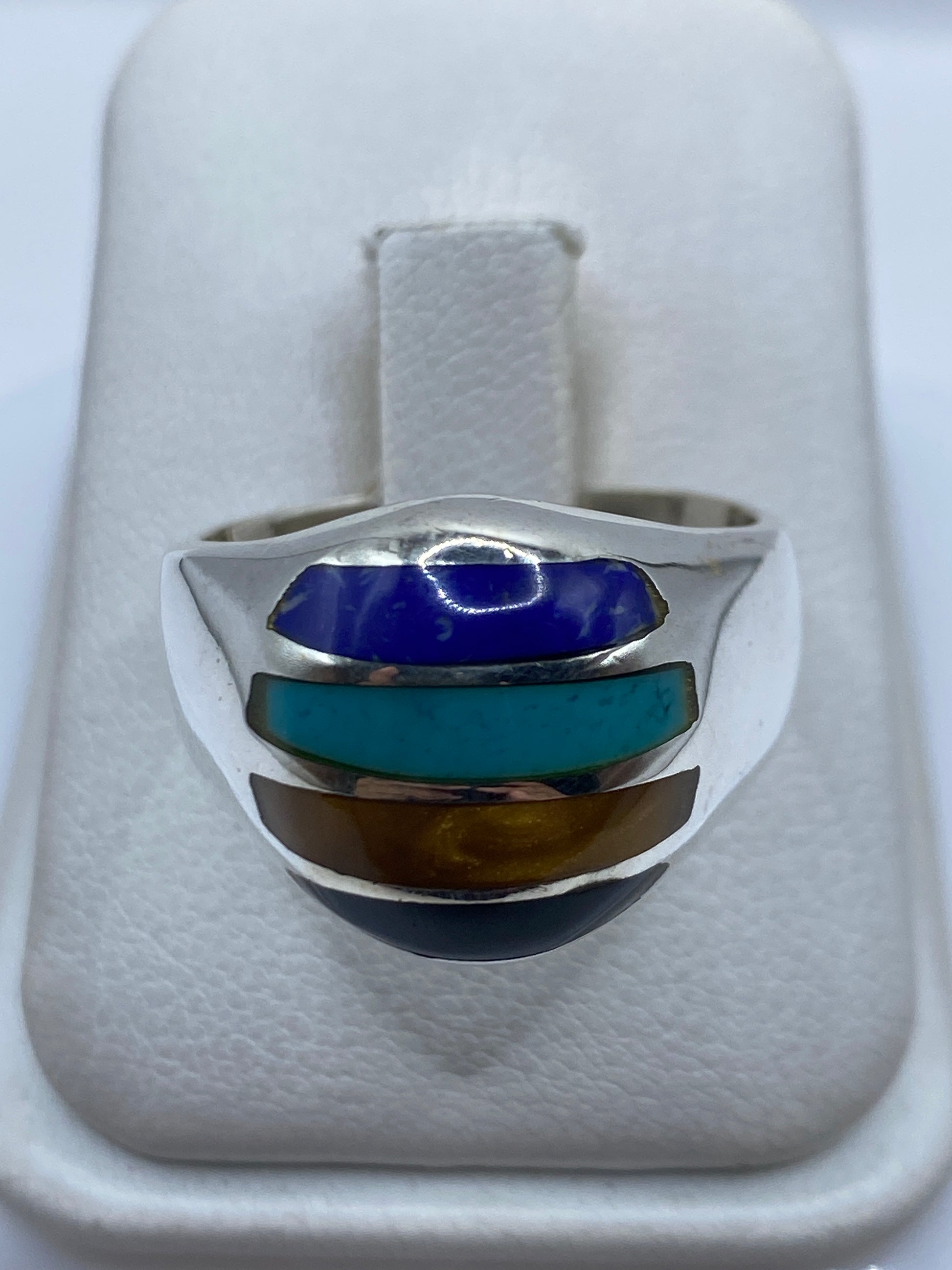 Anillo de plata con capas de turquesa azul cielo, ámbar y negro en vista frontal
