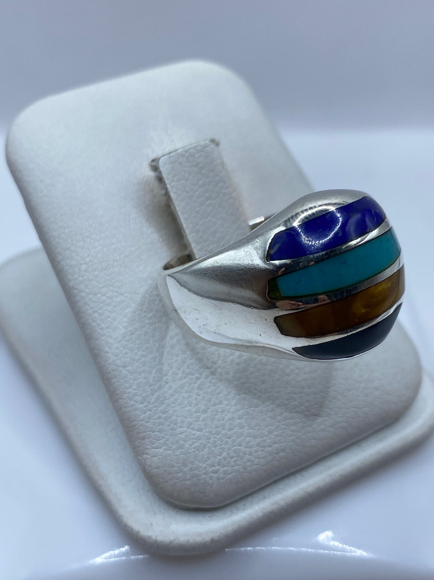 Anillo turquesa en mano mostrando los cuatro colores de piedra engastada